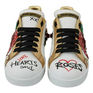 White sneakers with gold accents, black laces, rose embellishments, and hearts and roses text.