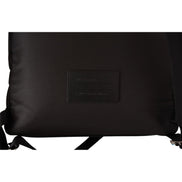 Close-up of black designer backpack with leather patch and adjustable straps