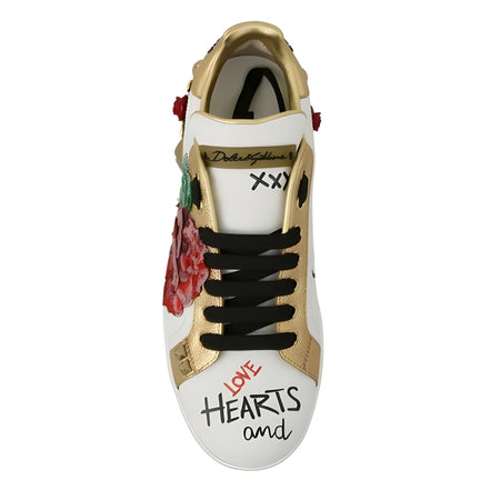 White and gold designer sneaker with black laces, red rose patch, and 'Love Hearts' text on toe